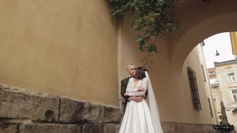 newlyweds, caucasian groom with bride walking, embracing, hugs in city, wedding couple in love