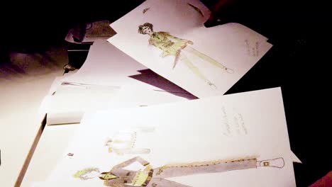 a fashion student looking through their drawings on a table for a costume for st patrick's day in ireland