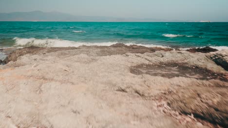 Reaching-a-beautiful-exotic-beach-in-a-Greek-Island-with-paragliders-flying-in-the-distance