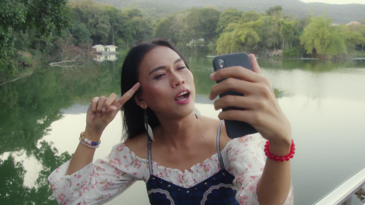 una mujer tomando una selfie junto al lago.