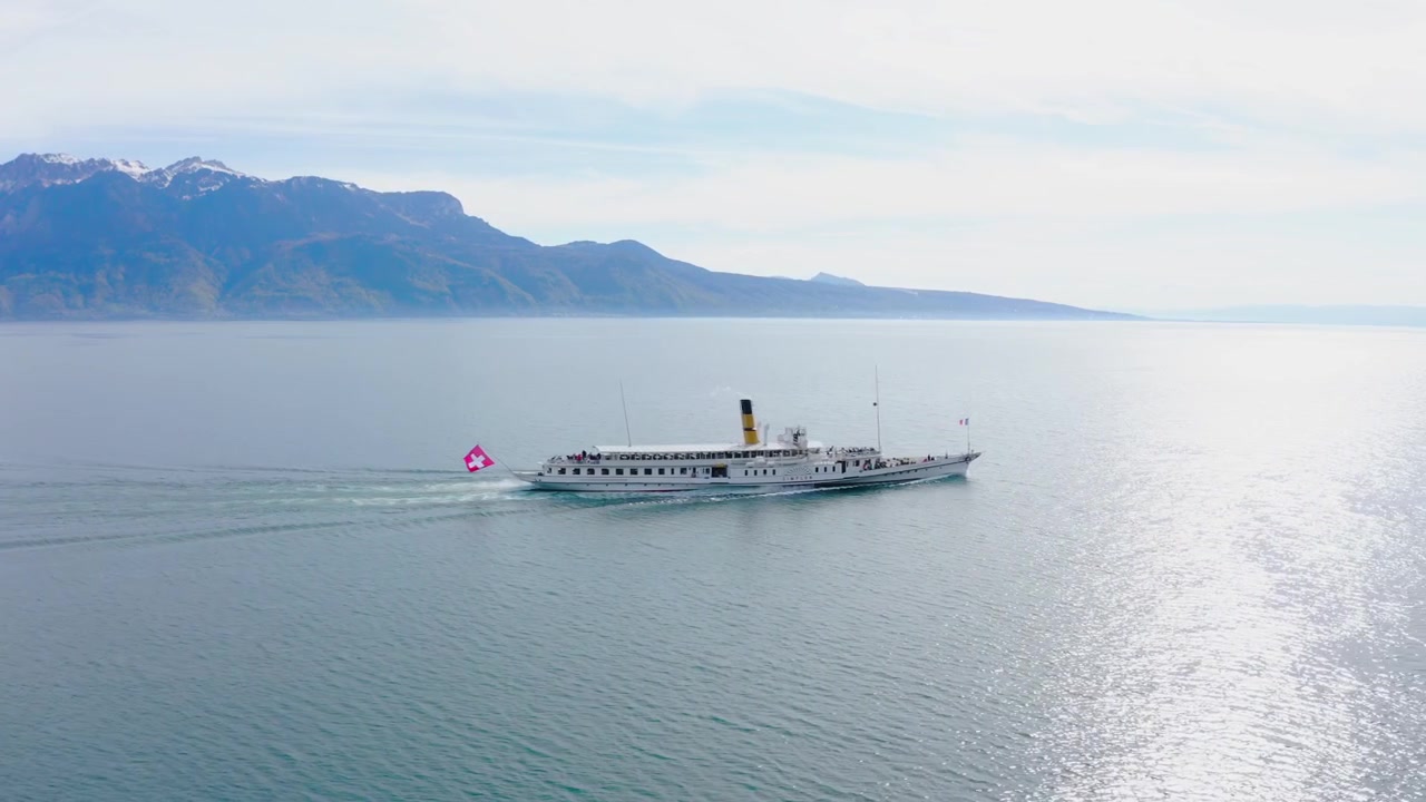 Droneoptagelse, der viser et vidvinkelbillede af en hjuldamper, der færger passagerer over en sø i Schweiz.