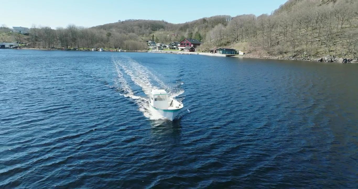 Kleines Motorboot fährt auf ruhigem Wasser bei Vanse, Norwegen.