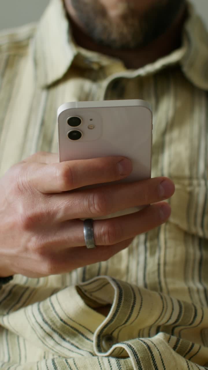 Persona che tiene uno smartphone bianco
