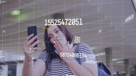 animación de números cambiantes sobre una mujer caucásica haciendo una videollamada en un teléfono inteligente en la calle