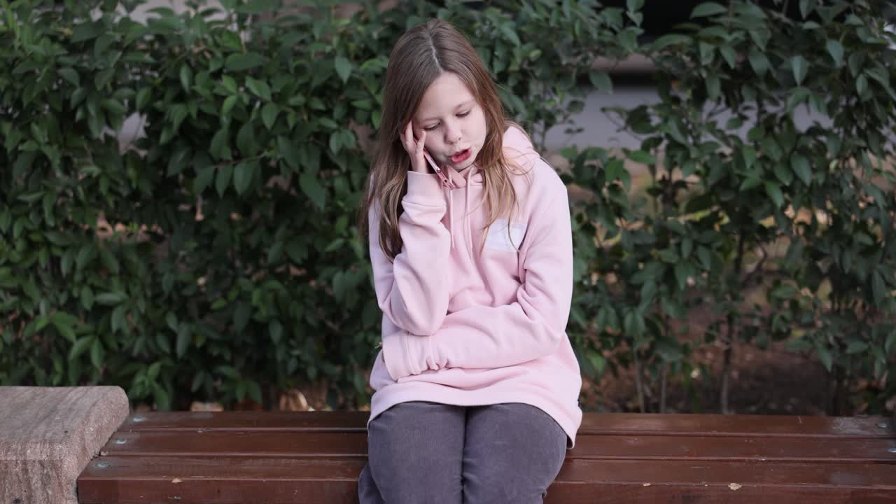 Girl talking on the phone while sitting on a bench
