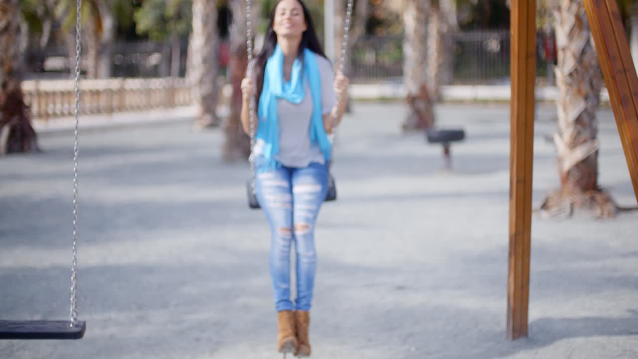 Joven feliz relajándose en un columpio