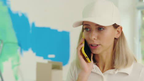 woman frustrated while talking on the phone during home painting