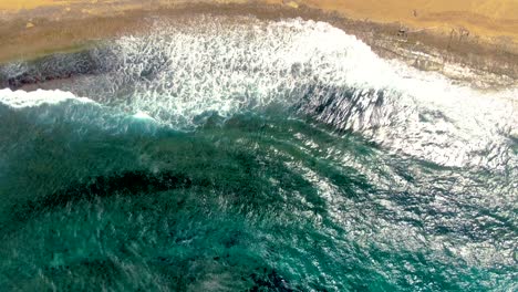 ocean waves wash over shore at costa de isabela, puerto rico, top down aerial