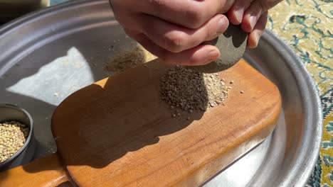 empujando semillas sabroso aroma fragante de hierbas por molienda hecha a mano molino de piedra de madera en el día el sol brilla día en el bosque la vida de la aldea de la montaña en los estados unidos arizona texas aborígenes vieja habilidad