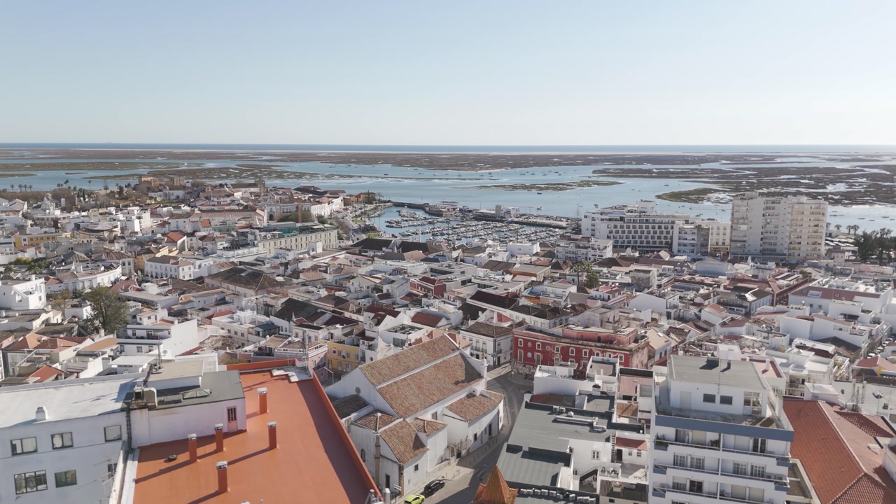 Rising view revealing the cityscape of Faro and its urban layout.