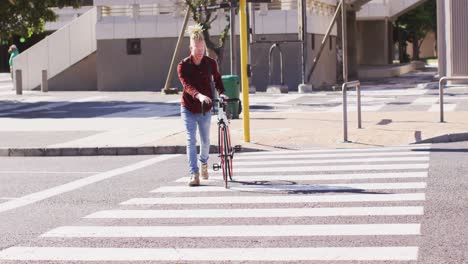 albino african american man with dreadlocks crossing road with bike