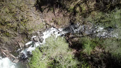 Descendiendo-Lentamente-En-Espiral-Sobre-Un-Remoto-Arroyo-De-Montaña,-Agua-En-Cascada,-Vista-Aérea-De-Dios