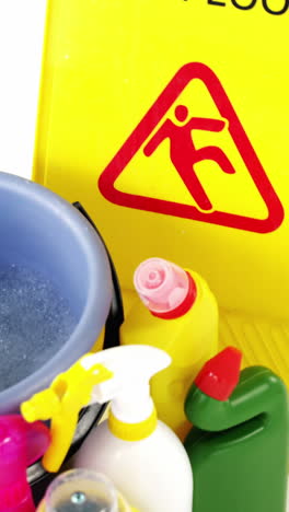 varios suministros de limpieza con un signo de precaución