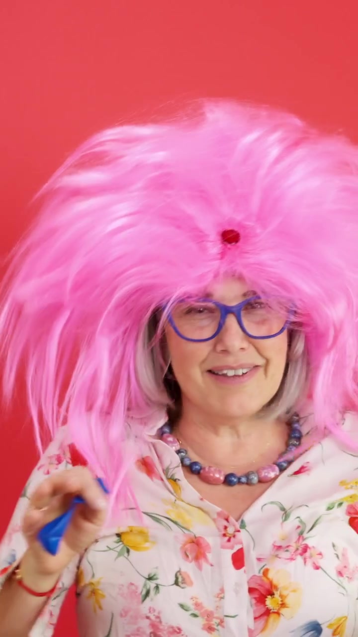 Funny senior woman with pink wig smiling