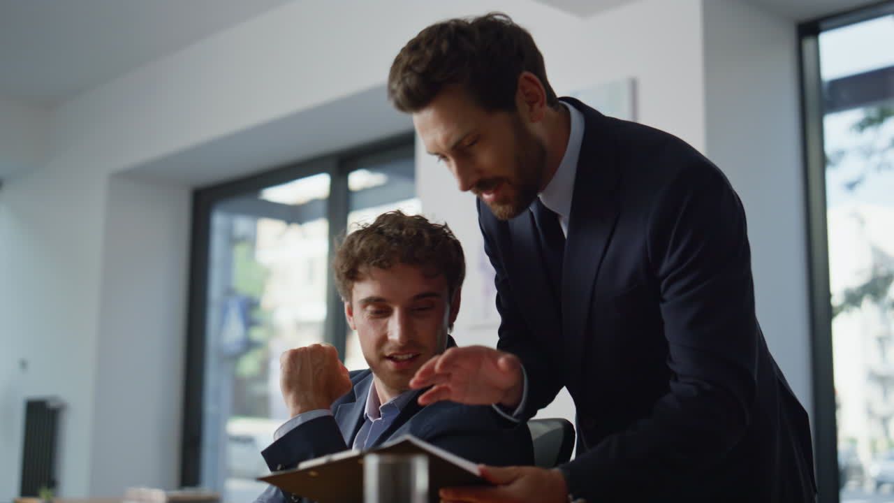 Serious intern typing computer corporate office closeup. Mentor helping manager