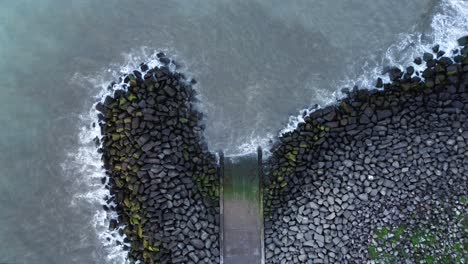 aerial drone shot of concrete slipway and rocky breakwater on hendon beach - sunderland, uk