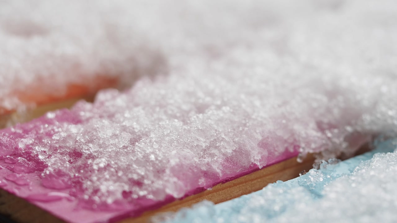 Close-up of Snow and Ice Melting on Colorful Wooden Planks