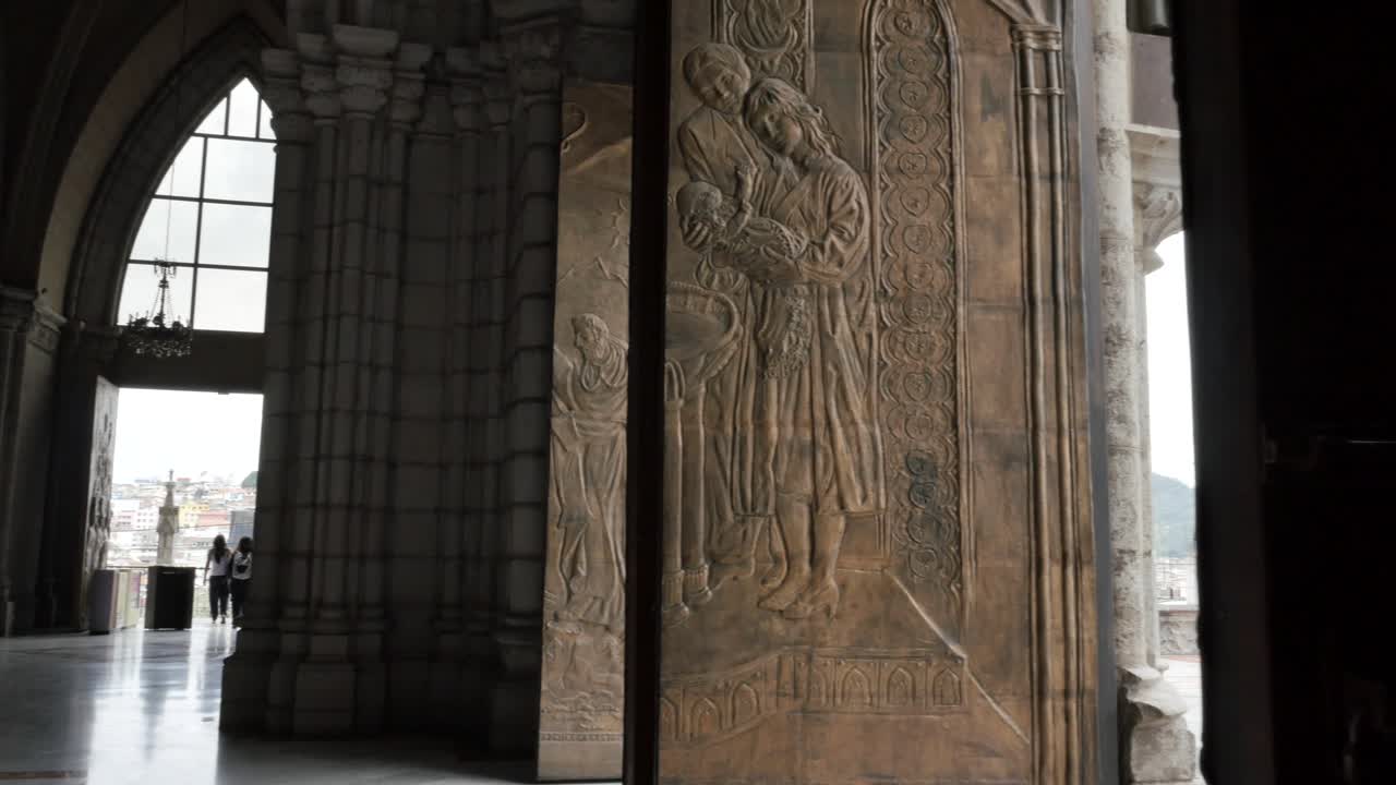 Vista pittoresca di intagli a mosaico su pilastro di pietra all'interno della Basilica del Voto Nazionale, Quito, Ecuador, primo piano, ripresa a mano con panoramica a destra.
