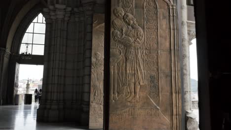 picturesque view of mosaic hand carvings on stone pillar inside basilica of the national vow, quito, ecuador, close up handheld pan right