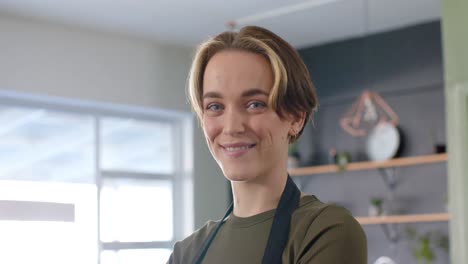 Portrait-of-caucasian-female-hairdresser-with-bob-and-highlights-smiling-at-salon,-in-slow-motion