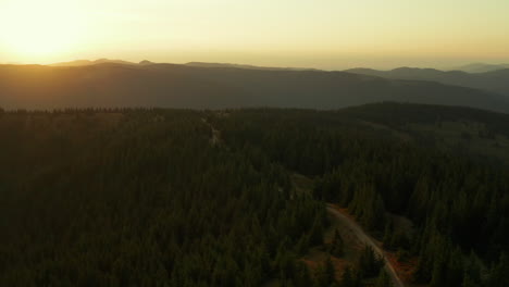 Vista-Aérea-Del-Amanecer-De-La-Montaña-Contra-El-Cielo-Dorado-De-La-Mañana-árboles-Verdes-Escena-De-La-Carretera