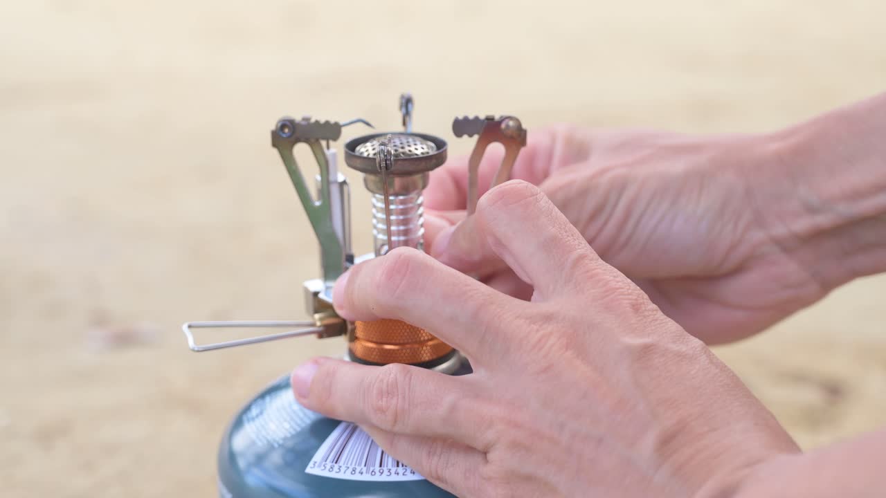 Using a portable gas stove to cook outdoors while camping