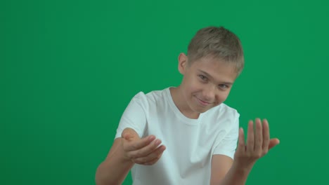 cheerful teenage boy inviting someone to come. kid portrait on green screen chroma key background. 4k video