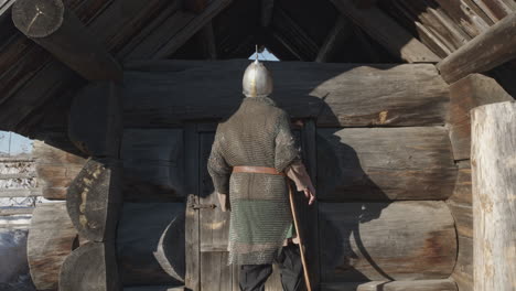 medieval knight at a wooden hut in winter