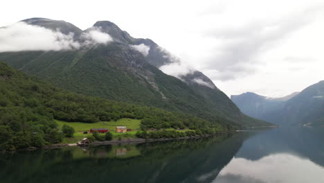 cabaña turística junto al lago, dnt hoemsbu en la orilla del lago eikesdalsvatnet en noruega rodeada de montañas, vista aérea