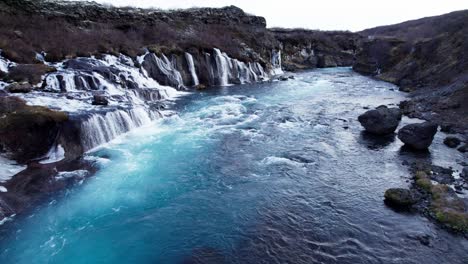 waterfall cascade hraunfossar in western iceland, aerial dolly