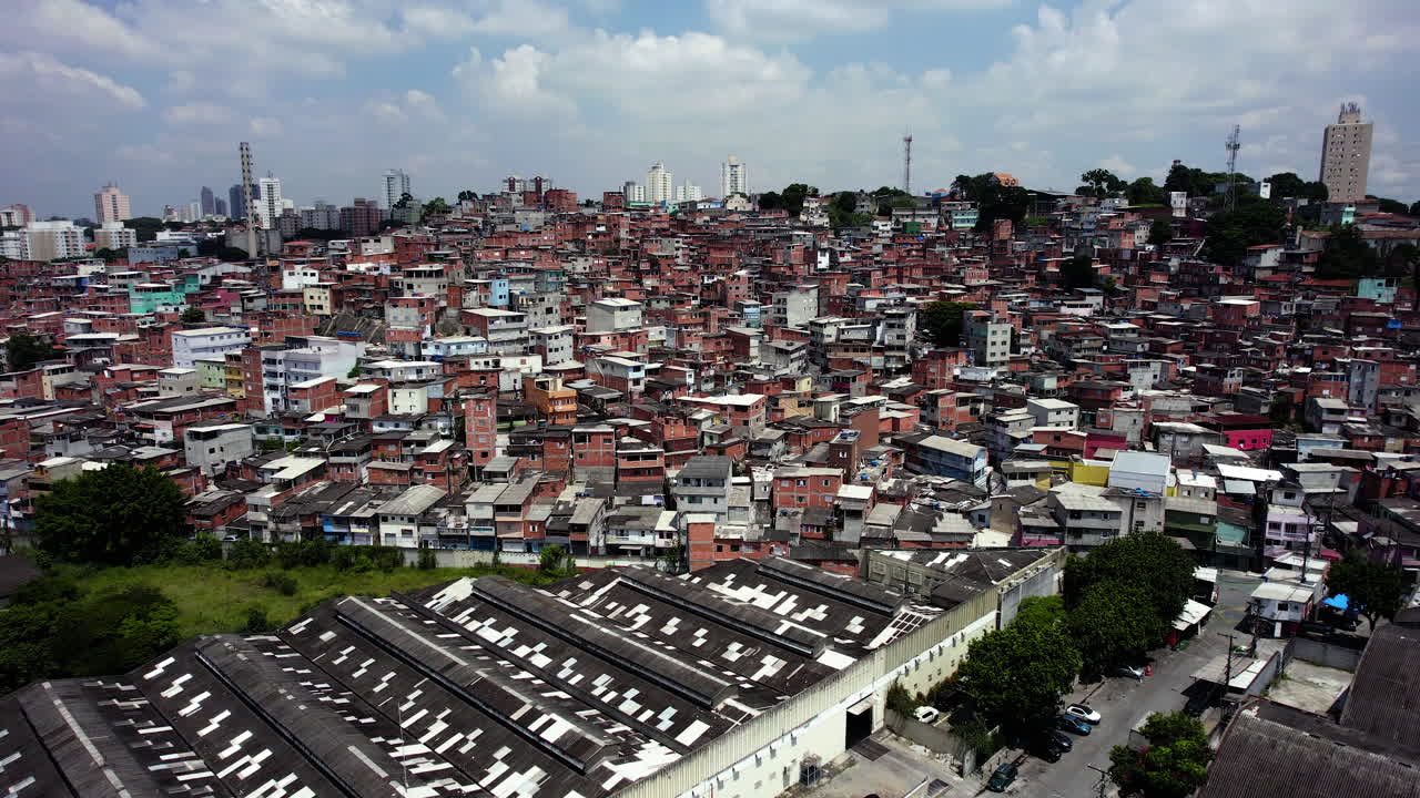 Approaching a shanty town daytime in the suburbs of Sao Paulo, Brazil - aerial view