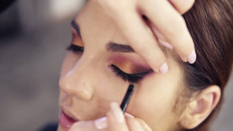 Applying-black-eyeliner-on-the-upper-lashline-close-up-slow-motion-footage.