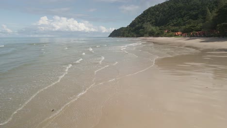 low-angle-aerial-drone-shot-of-man-running-on-tropical-beach-on-Island-in-Thailand