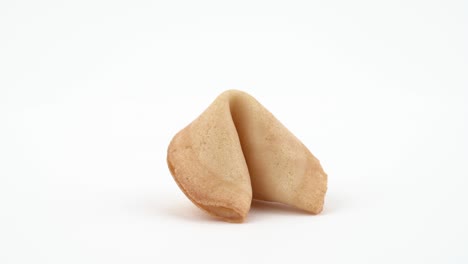 close-up circling around shot of cookie with prediction spinning slowly on the table. isolated, on white background.