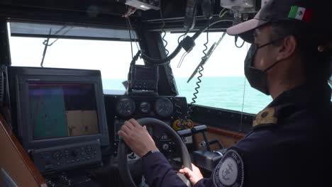 mexican marines sailing and driving at the bridge of a a patrol boat