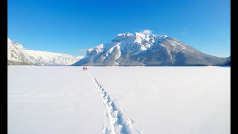 skier couple walking on snowy landscape 4k