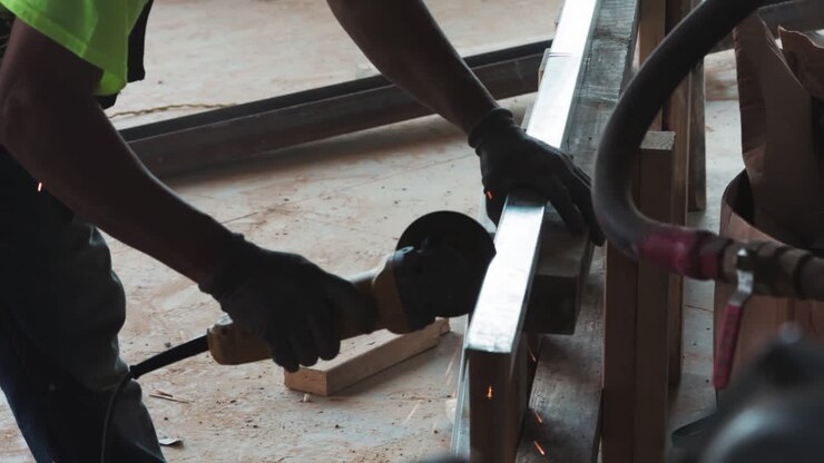 Slow motion coverage of a worker cutting steel on a construction job site