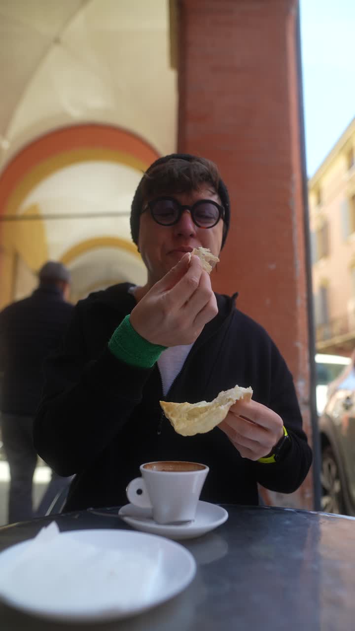 Person Eating Bread and Coffee in an Outdoor Cafe