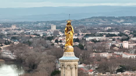 majestuosa estatua dorada de pie en avignon, irradiando brillo contra el