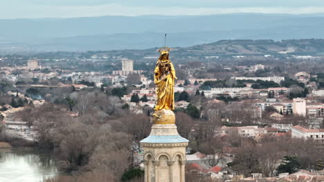 majestic golden statue standing tall in avignon, radiating brilliance against th