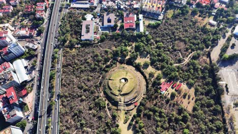 ancient cuicuilco pyramid seen from above, surrounded by urban mexico city