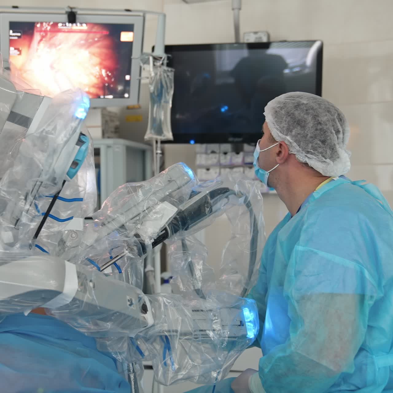 Doctor performs surgery with robotic equipment. Medical robot in modern operating room. Professional surgeon observes the work of surgical robot on the screen