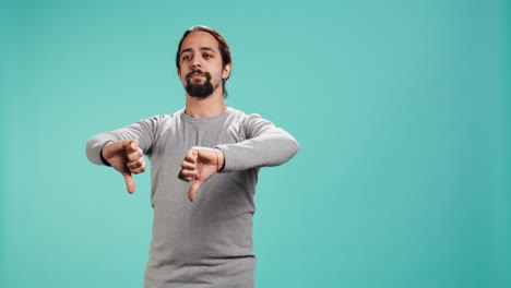 hombre molesto mostrando los pulgares hacia abajo señal haciendo gestos, siendo desaprobador