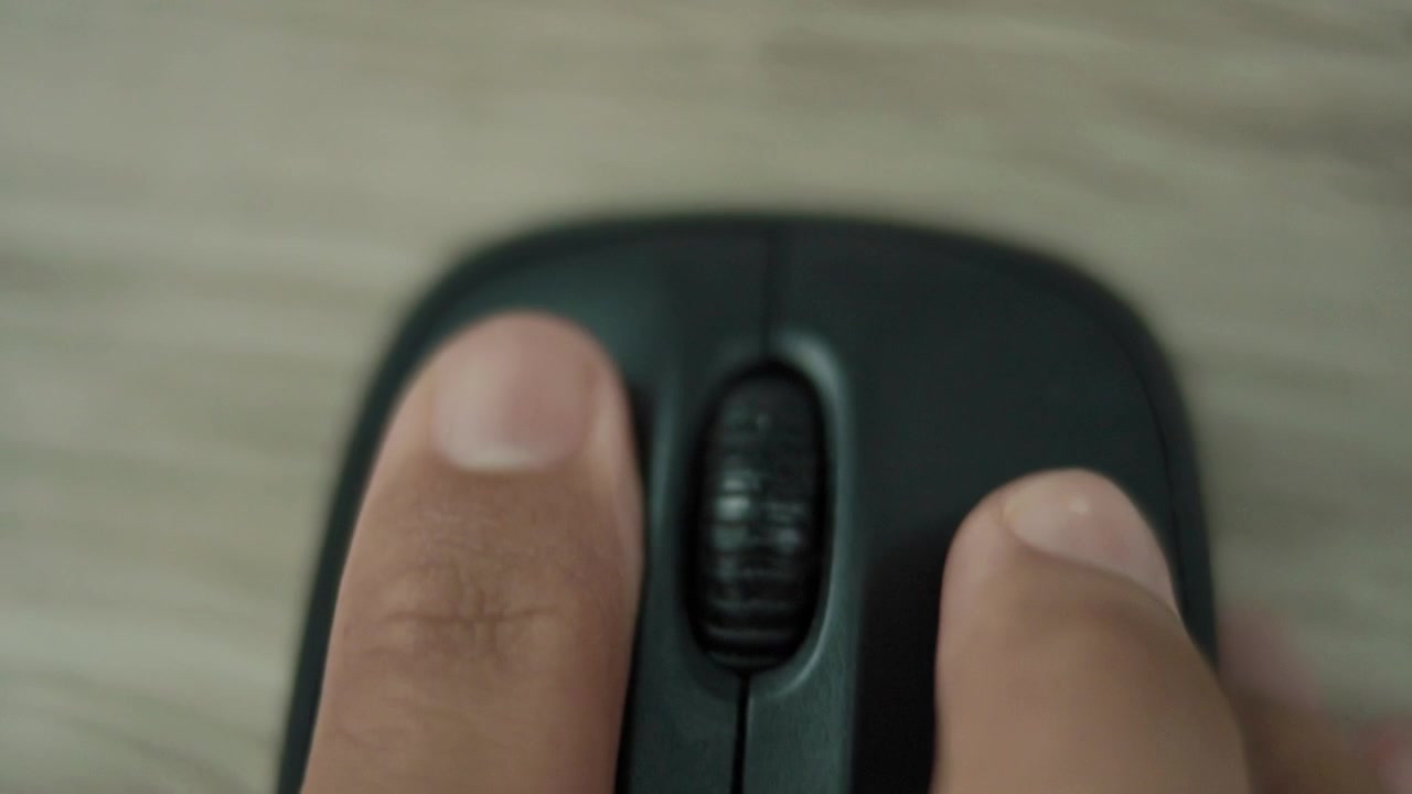 Top View Hand using computer wireless mouse in film tone style, Extreme close up view, switching focus to click the mouse.