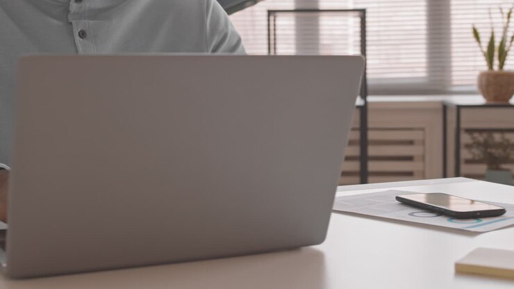 Mann, auf Laptop tippend, im Anschnitt