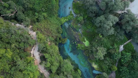 aerial drone captures albania’s blue eye nature preserve, revealing its vibrant turquoise spring, scenic hiking trails, and nearby resort, blending natural beauty with serene relaxation