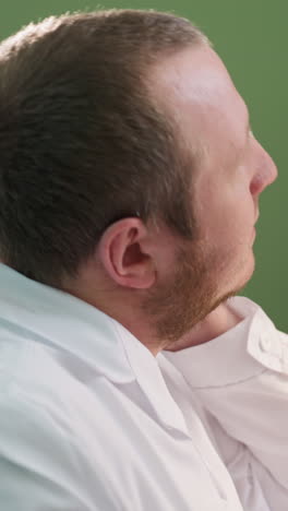 una vista de cerca de un técnico en una bata de laboratorio blanca estirando y frotando su cuello