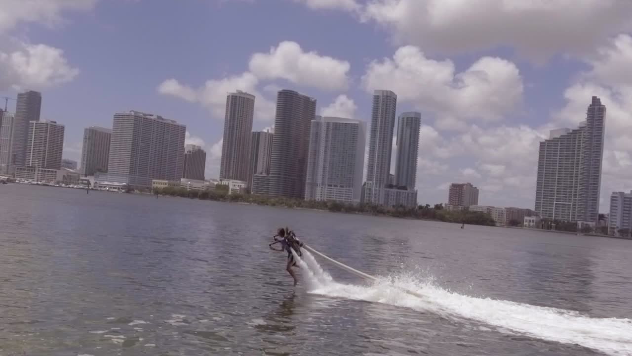 Un uomo si libra usando un jetpack acquatico Flyboard sull'oceano a Miami, Florida