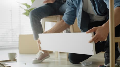 tracking video of couple checking manual before installing furniture.