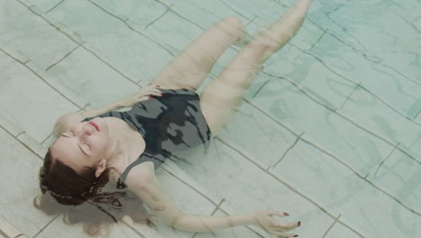 mujer de pelo largo sentada en la piscina